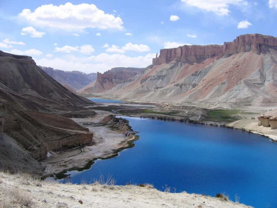 Travel guide to Afghanistan featuring the turquoise travertine lakes of Band-e Amir surrounded by towering red desert cliffs