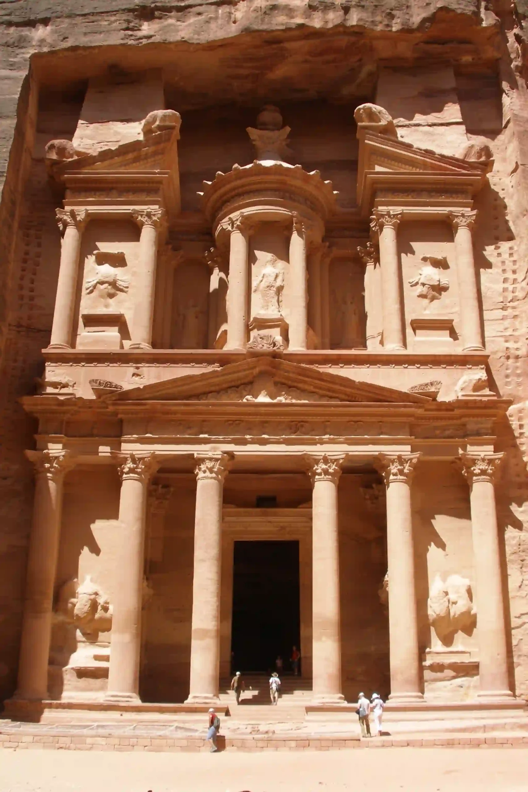 Travel guide to Jordan featuring the Treasury carved into the rose-red rock cliffs of Petra