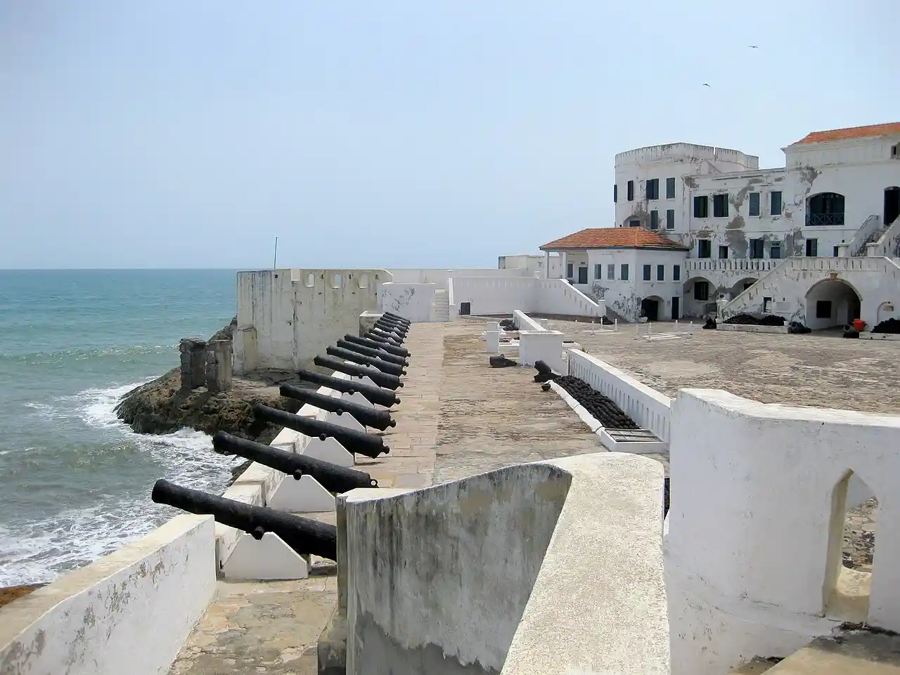 Travel guide to Ghana featuring the historic Cape Coast Castle sitting along the Atlantic oceanfront