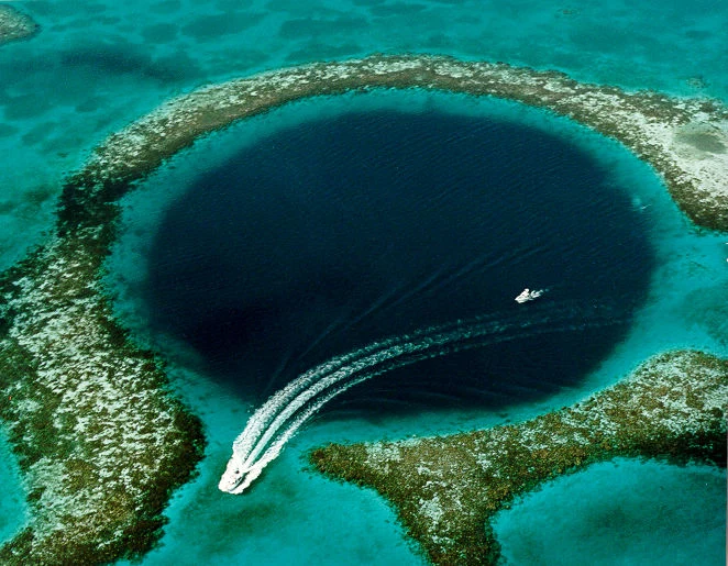 Travel guide to Belize featuring an aerial view of the Great Blue Hole in the Belize Barrier Reef