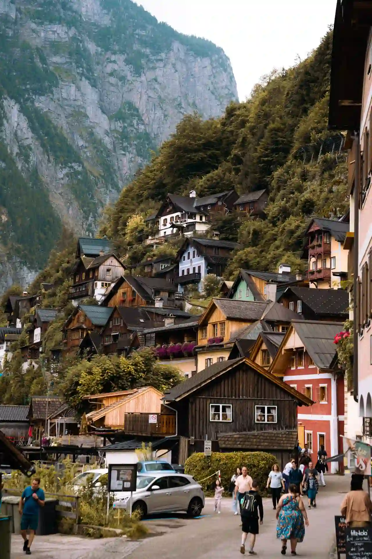 Travel guide to Austria featuring historic wooden alpine chalets overlooking the serene lake and mountain landscape of Hallstatt