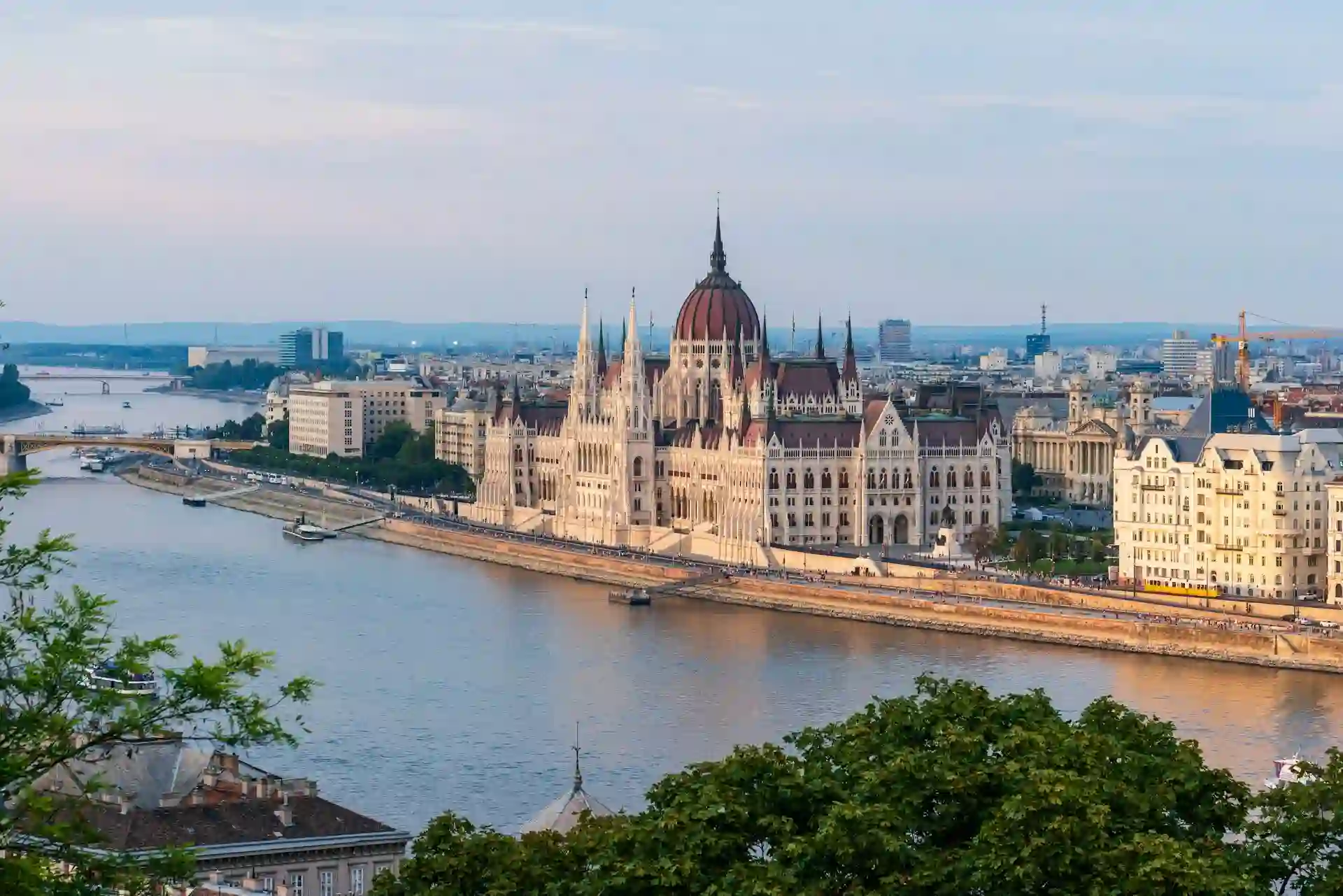 Travel guide to Hungary featuring the Hungarian Parliament Building lit up along the Danube River in Budapest