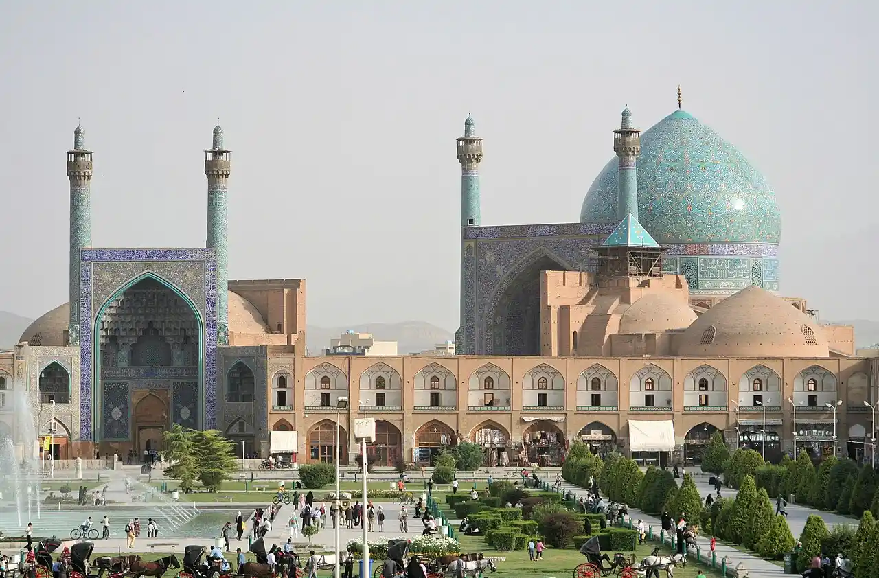 Travel guide to Iran featuring the grand archways and blue tile mosaic dome of Shah Mosque in Isfahan