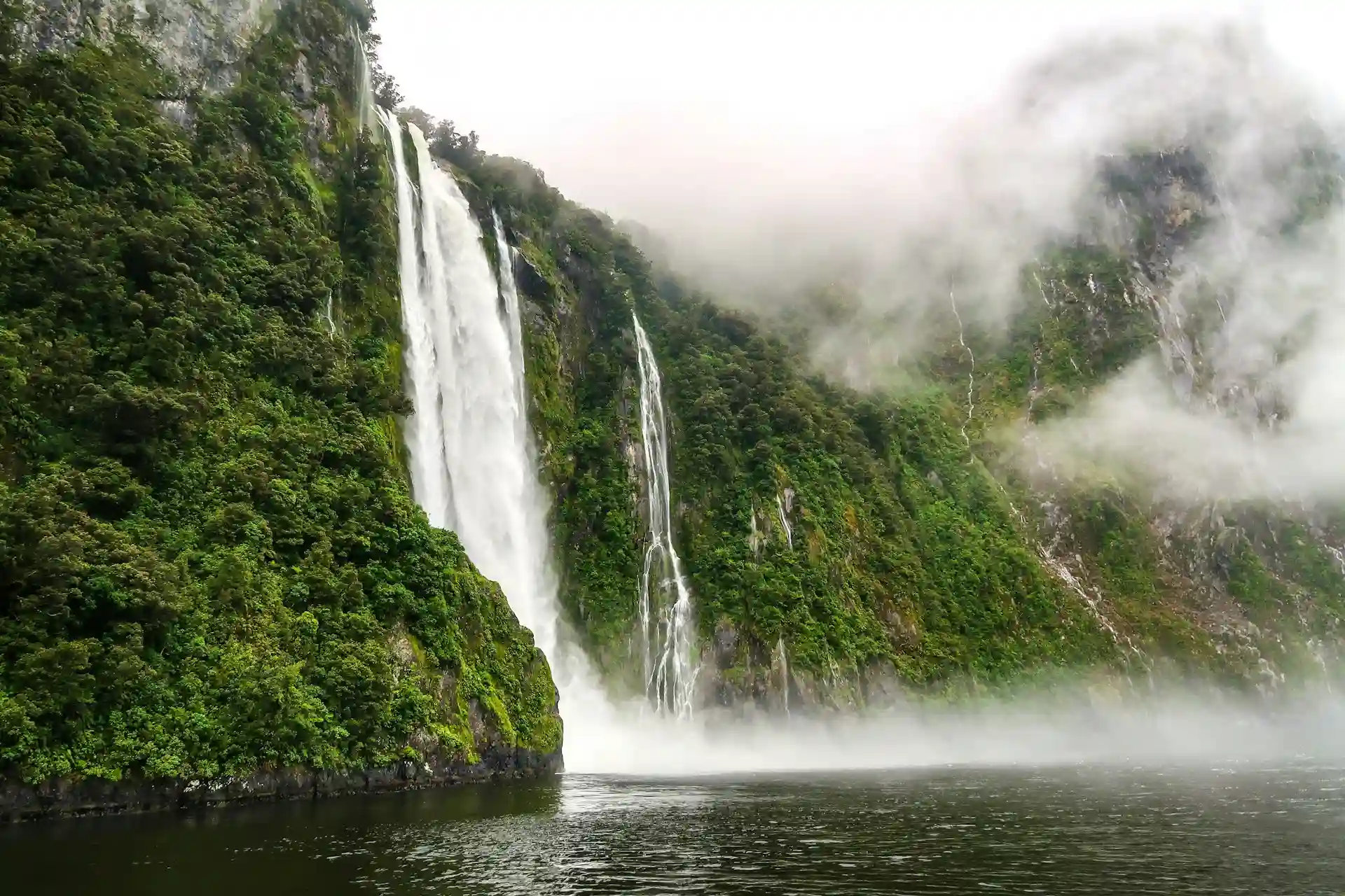 Travel guide to New Zealand featuring Milford Sound and snow-capped mountains