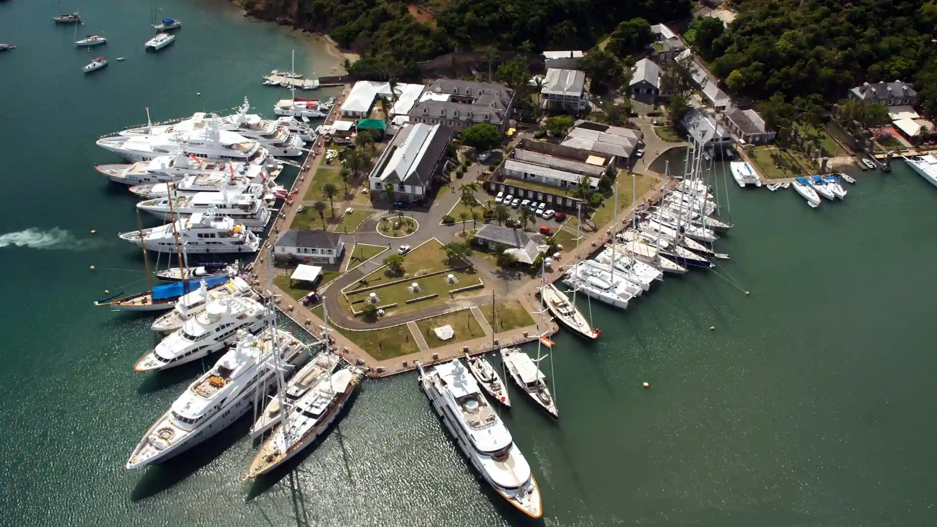 Travel guide to Antigua and Barbuda featuring luxury yachts anchored in the turquoise bay of Nelson's Dockyard in English Harbour