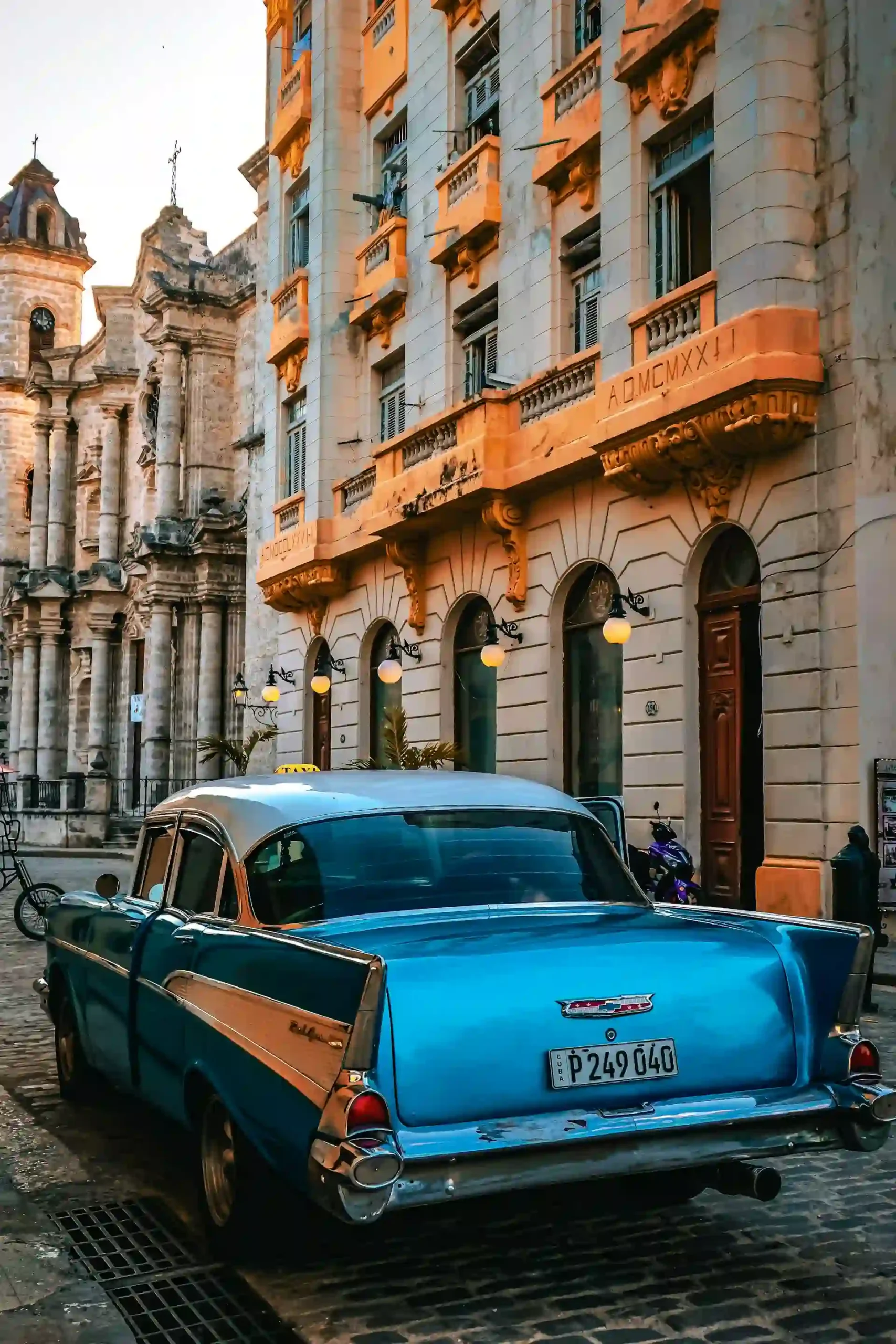 Travel guide to Cuba featuring classic colorful 1950s American cars parked along historic colonial buildings in Old Havana