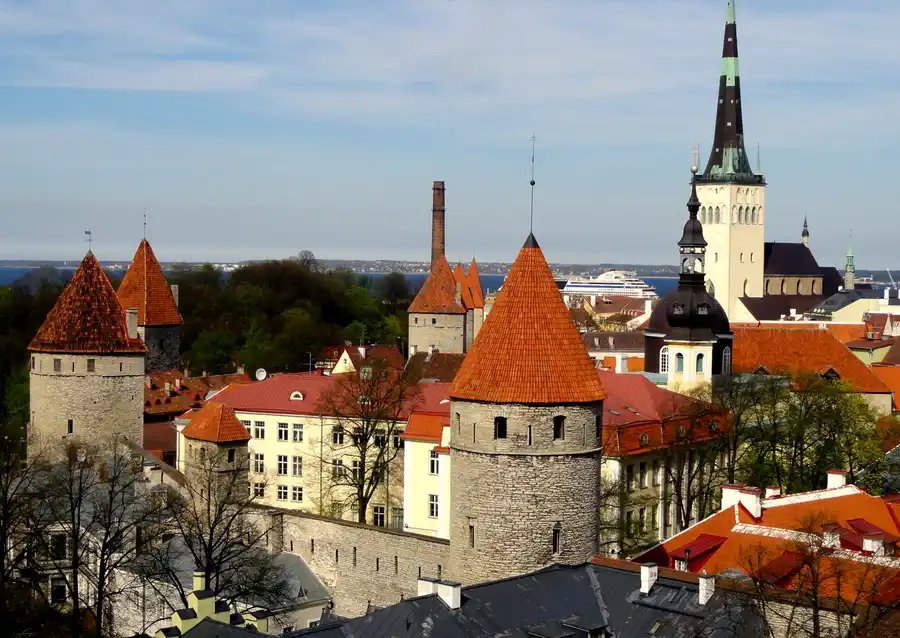 Travel guide to Estonia featuring the cobblestone streets and medieval red-tiled towers of Tallinn Old Town