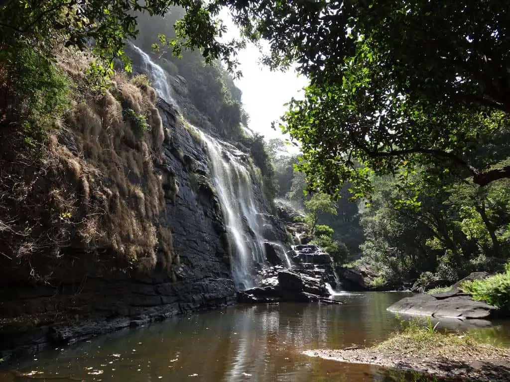Travel guide to Guinea featuring a breathtaking cascading waterfall in the lush Fouta Djallon highlands