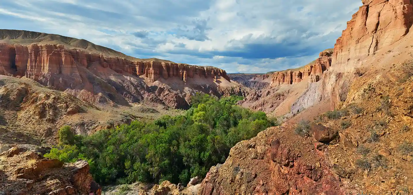 Travel guide to Kazakhstan featuring dramatic red sandstone rock cliffs in Charyn Canyon