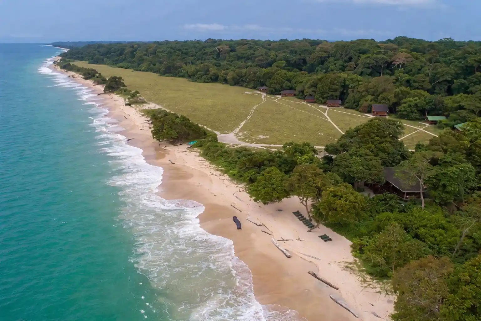 Travel guide to Gabon featuring an pristine Atlantic beach bordering dense tropical rainforest in Loango National Park